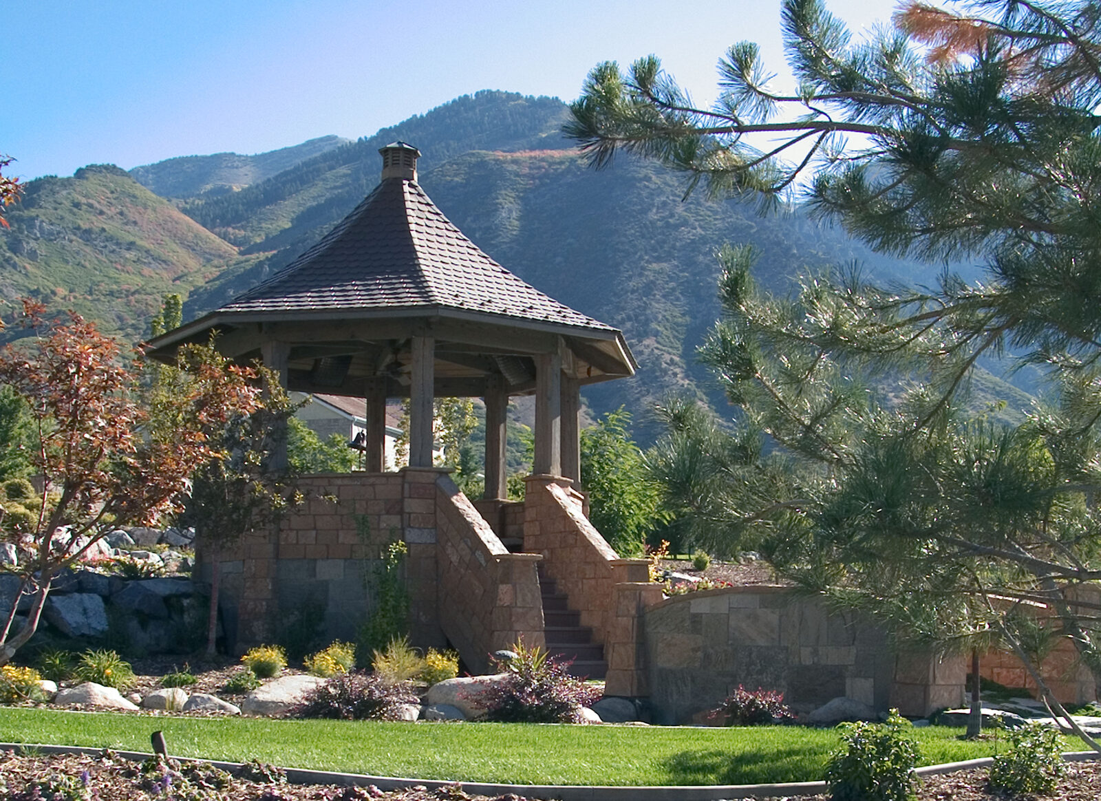 Octagonal gazebo with stone base, mountain backdrop